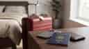 A collection of travel items including a rolling suitcase, smartphone, passport and wallet.