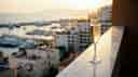A glass of champaign sitting on the railing of a high-end hotel room.