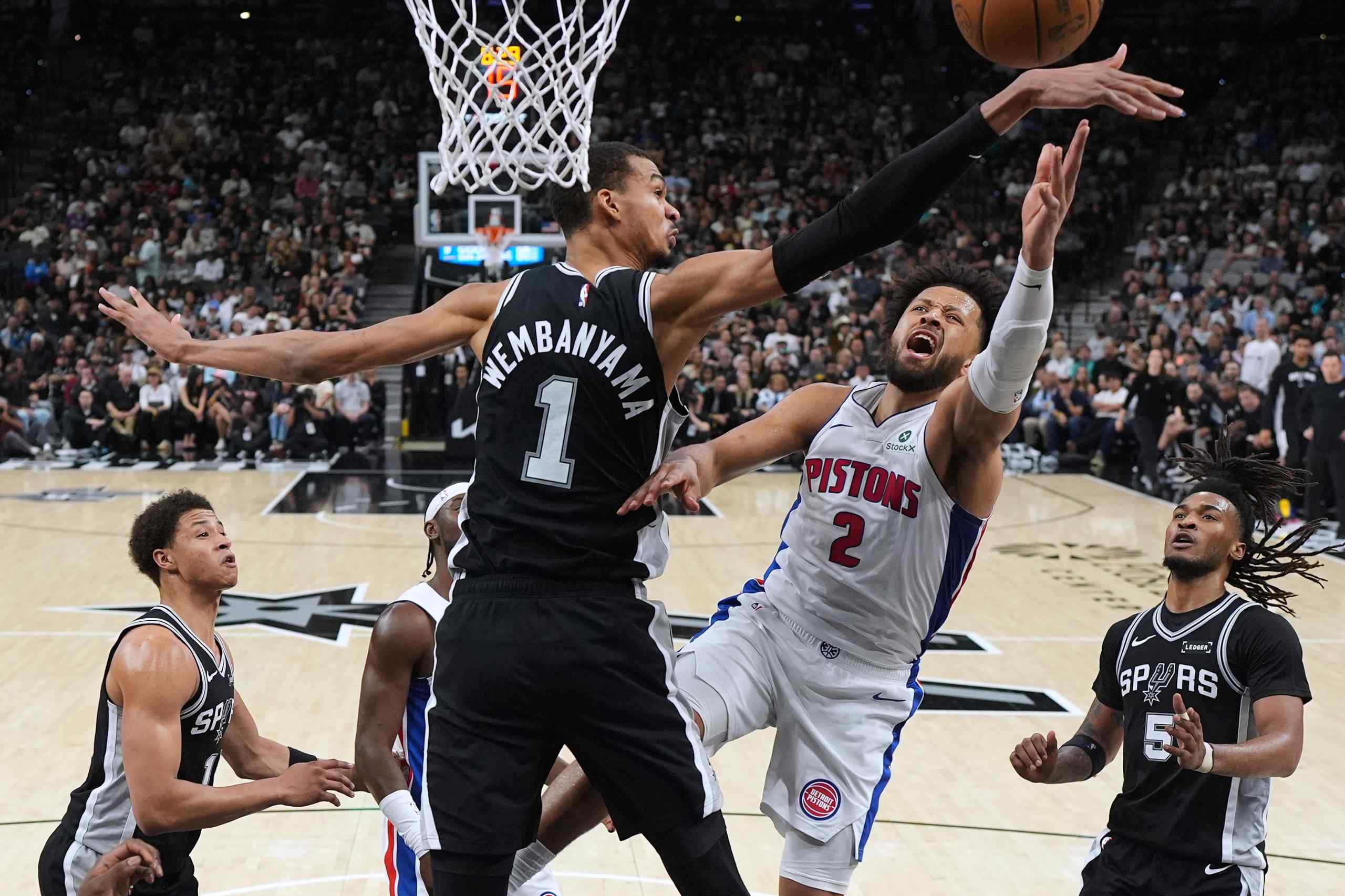 Spurs star forward Victor Wembanyama contests Pistons leading scorer Cade Cunningham at the rim.  