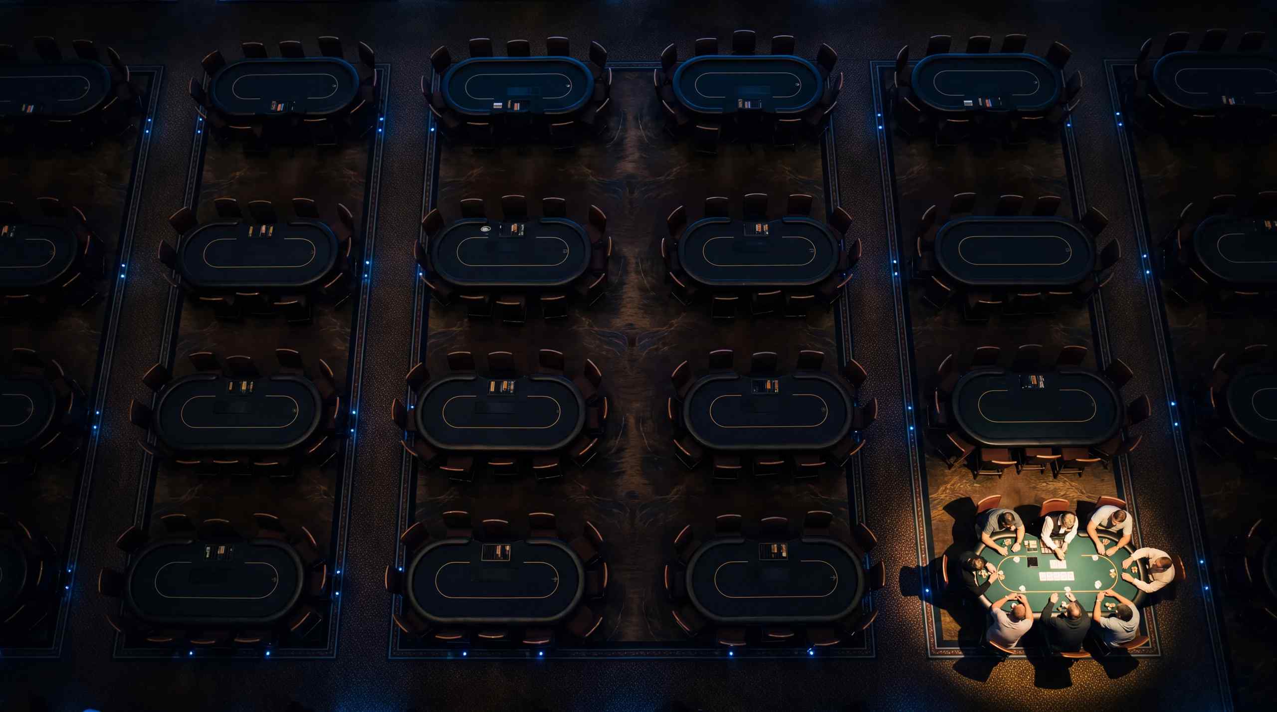 A single poker table in a dark room.