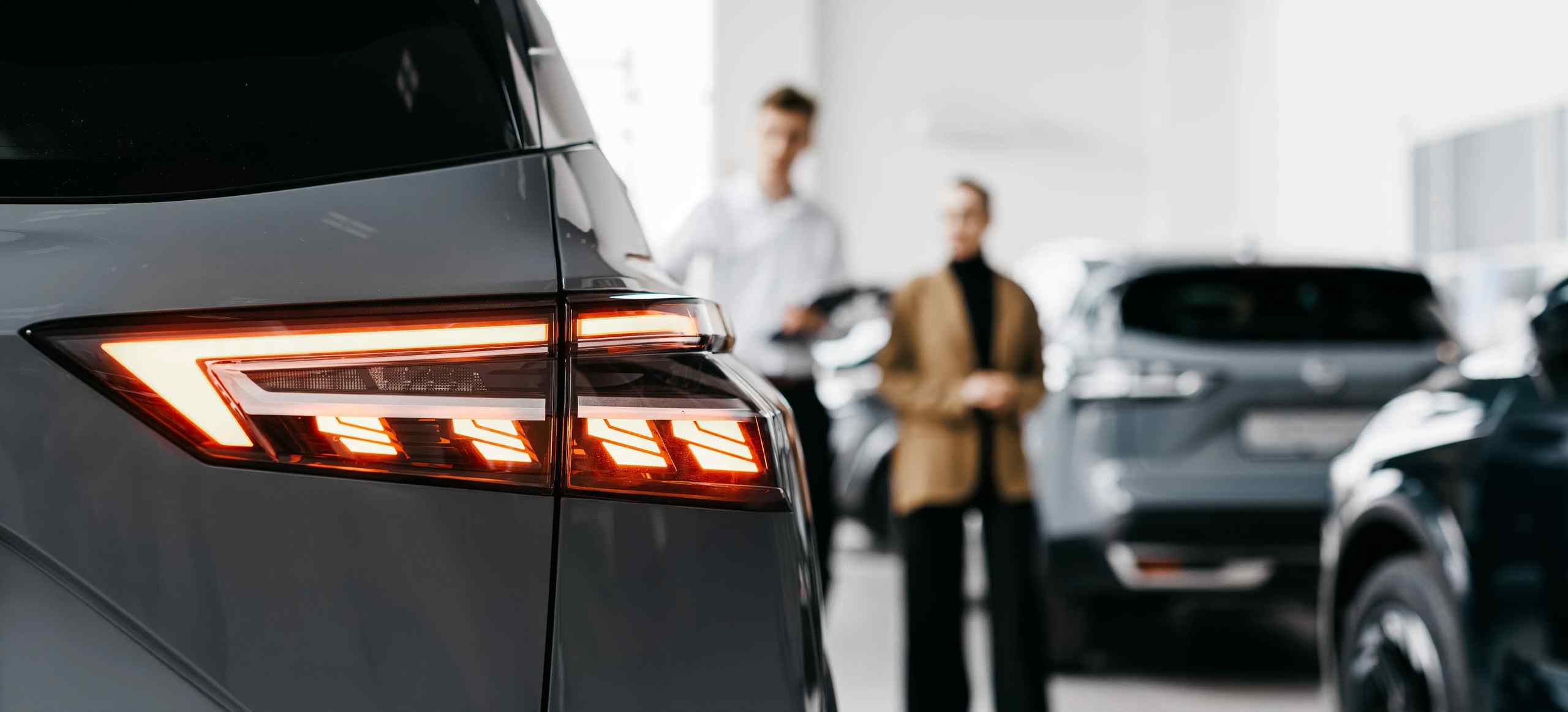 A car dealership associate talking to a customer.