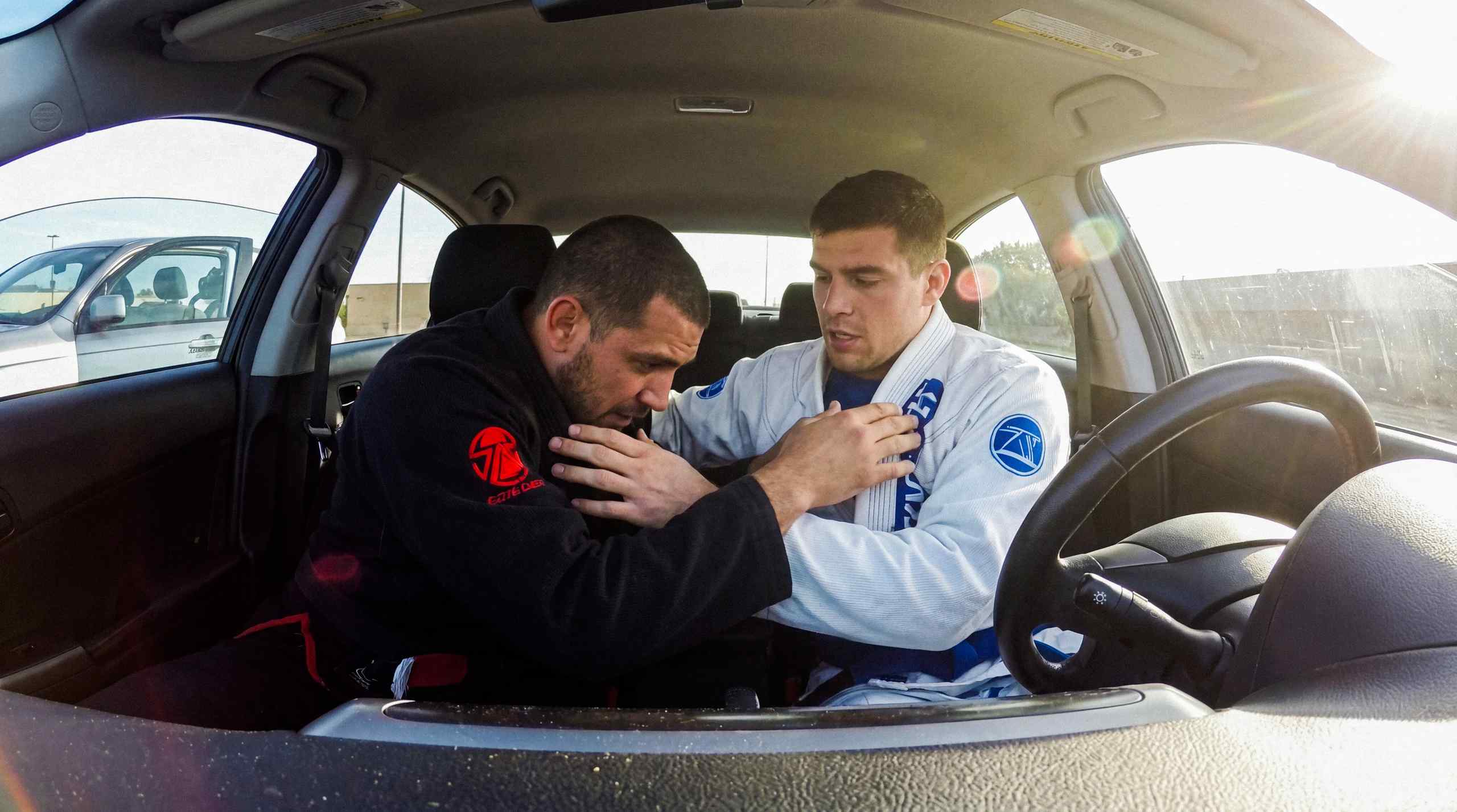 Two men wrestling in a car in a Car-Jitsu match.