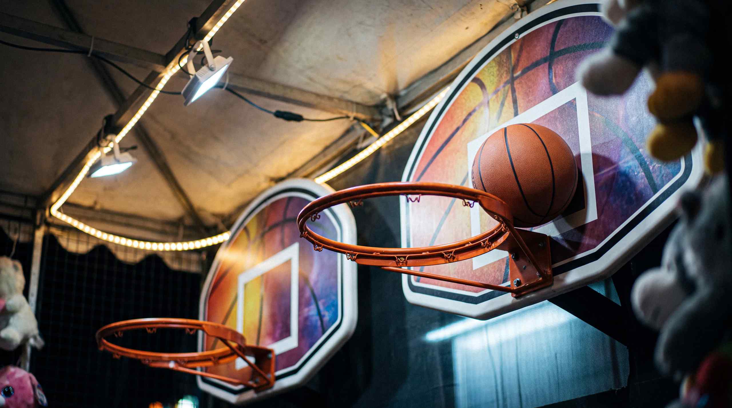 A basketball missing the net in a carnival game.