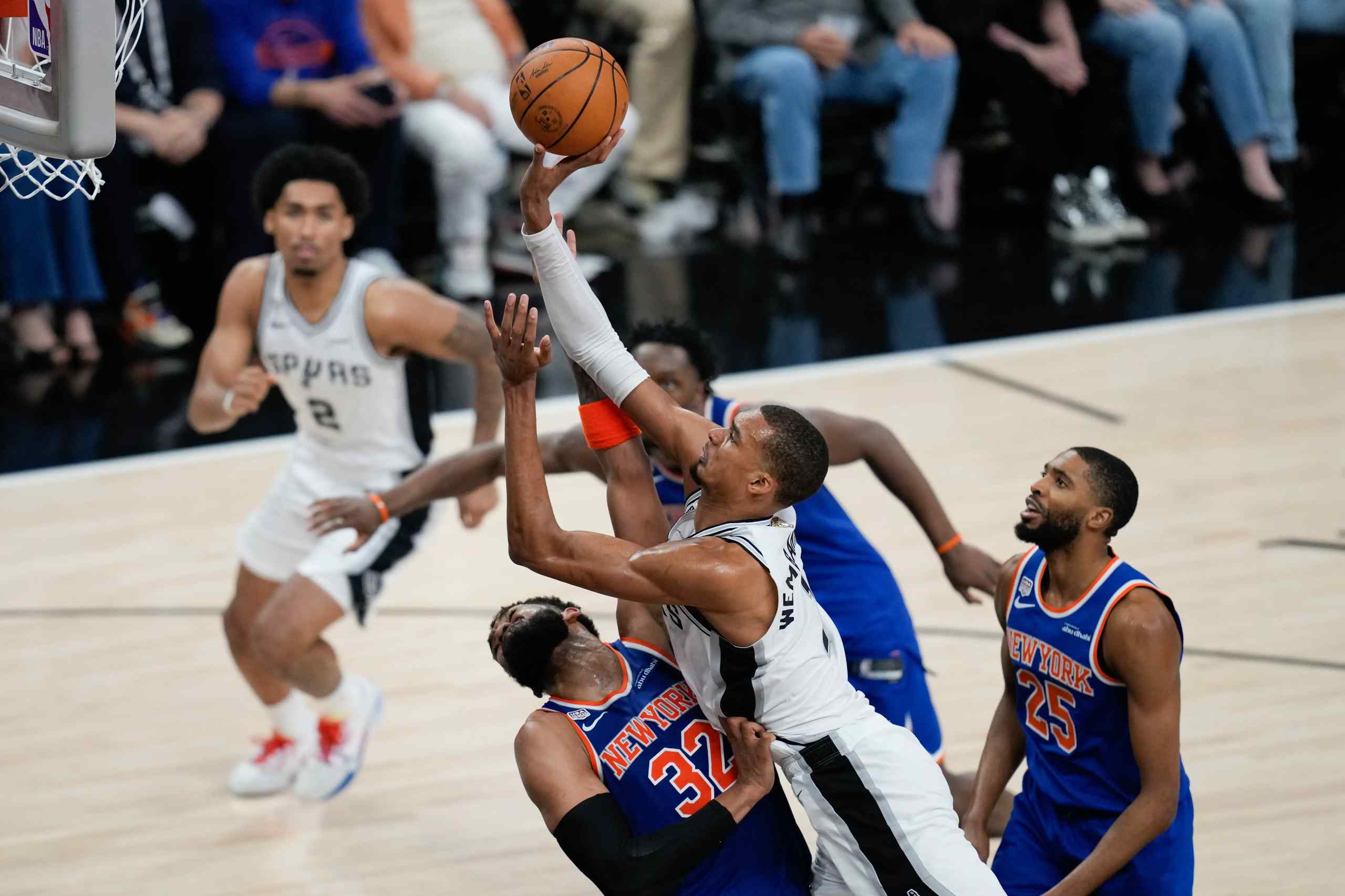 San Antonio Spurs forward Victor Wembanyama shoots the ball while being fouled by New York Knicks center Karl-Anthony Towns 