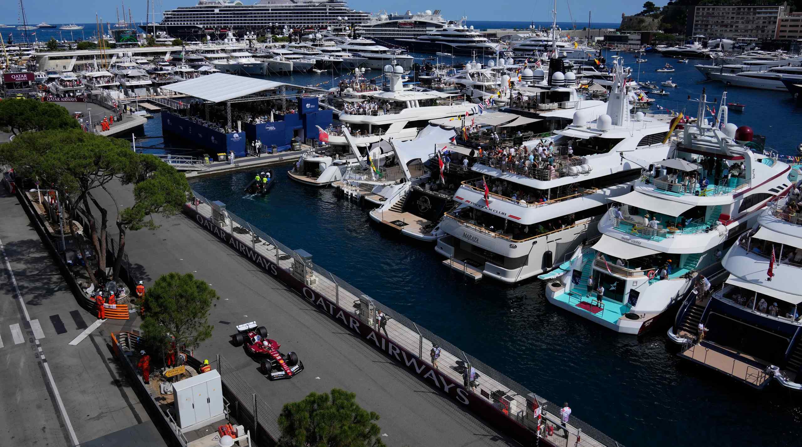 An F1 race car next to a group of yachts.