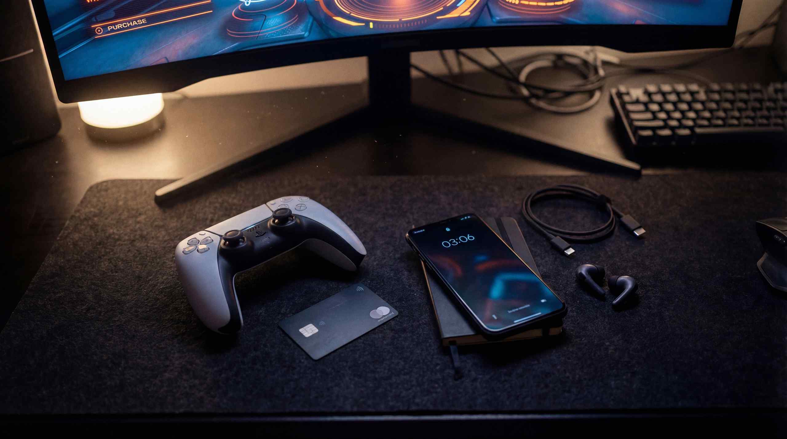 An image of a PS5 controller, credit card and smartphone.