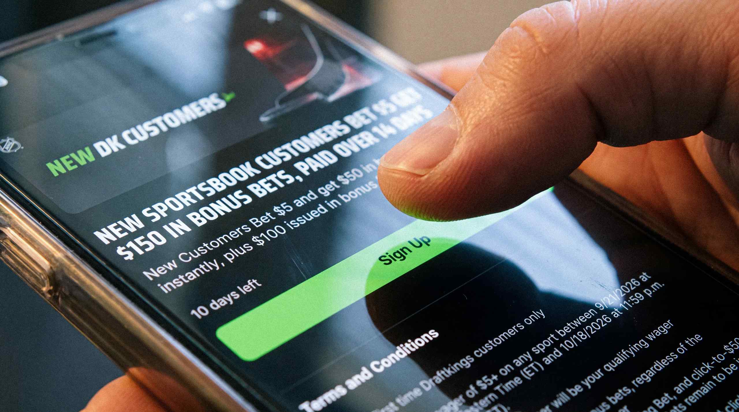 Someone clicking sign-up for a sports betting app on a mobile device.