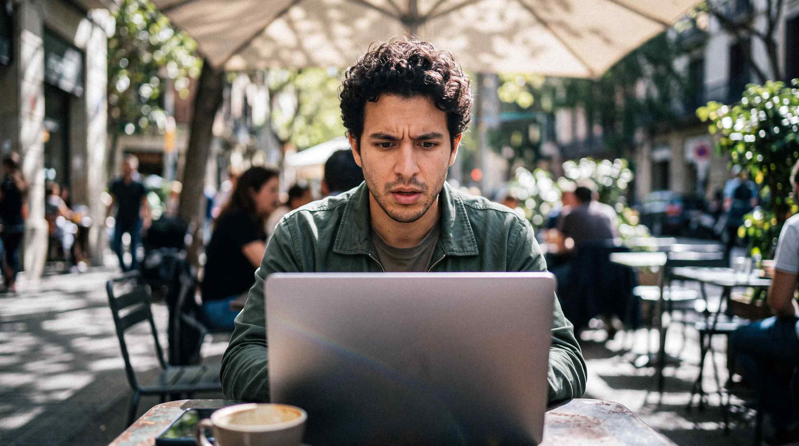 A man struggling while using a laptop