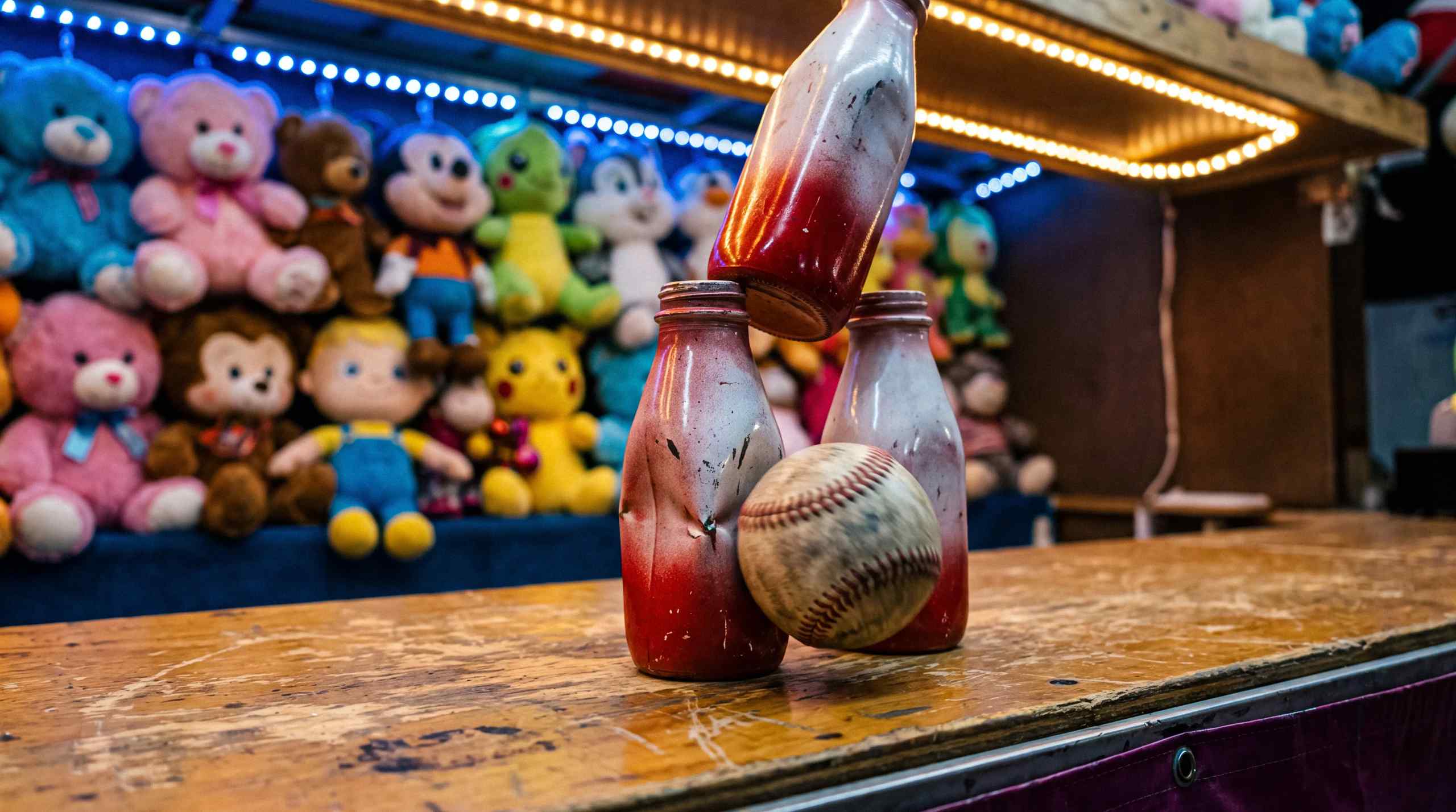 A baseball smashing into milk bottles at a carnival.