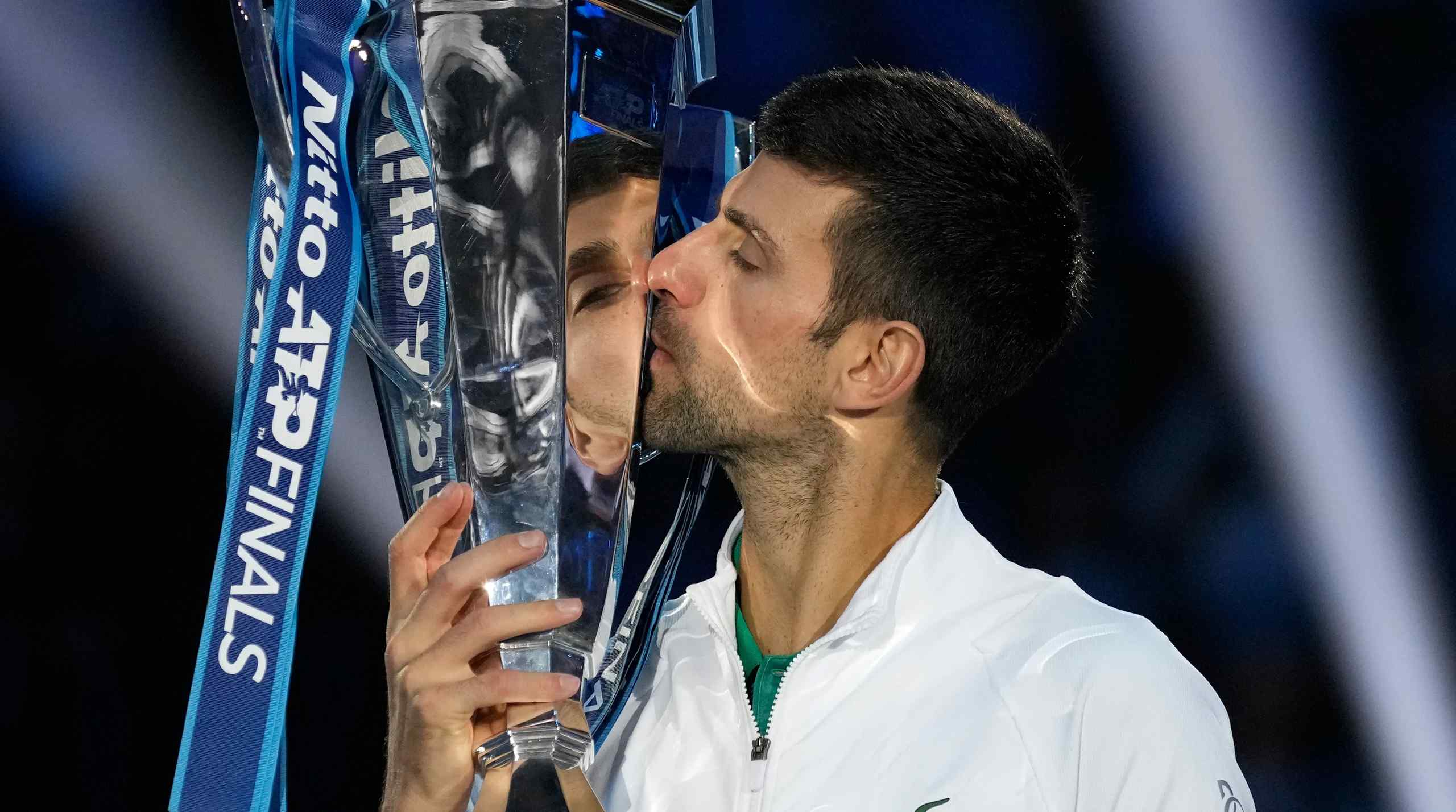 Novak Djokovic kissing a trophy.