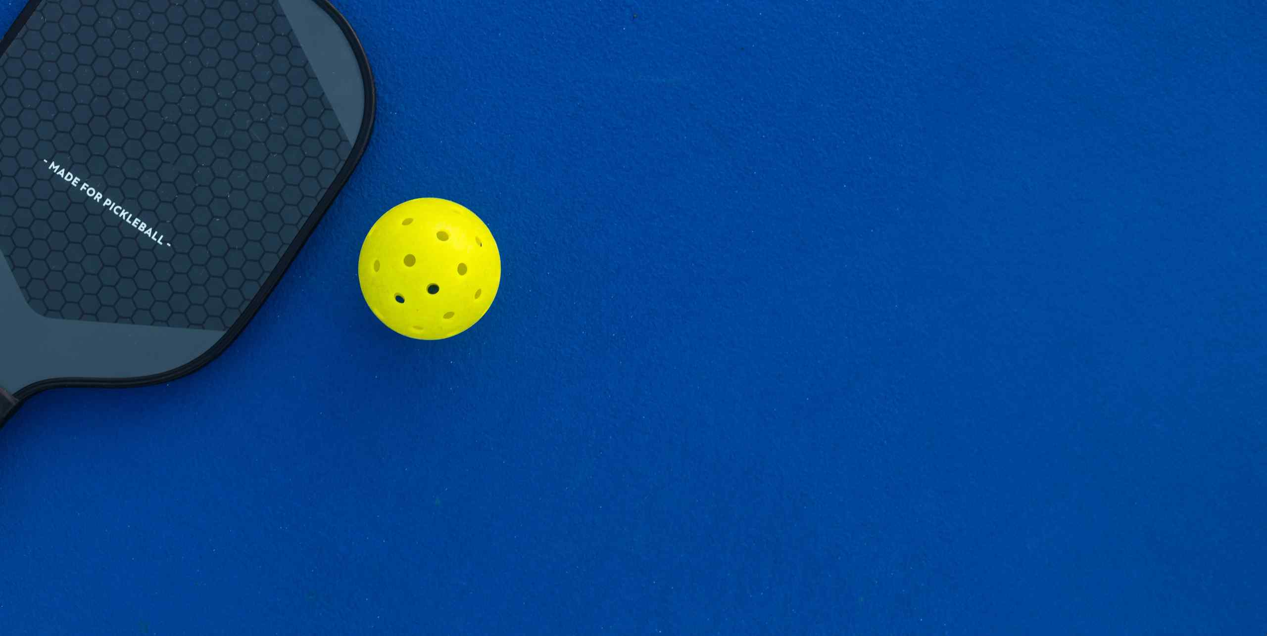 A pickleball and paddle