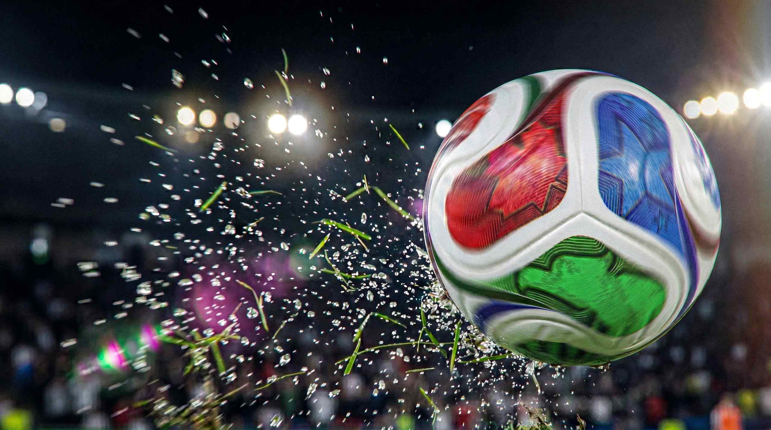 soccer ball, water, and grass kicked up