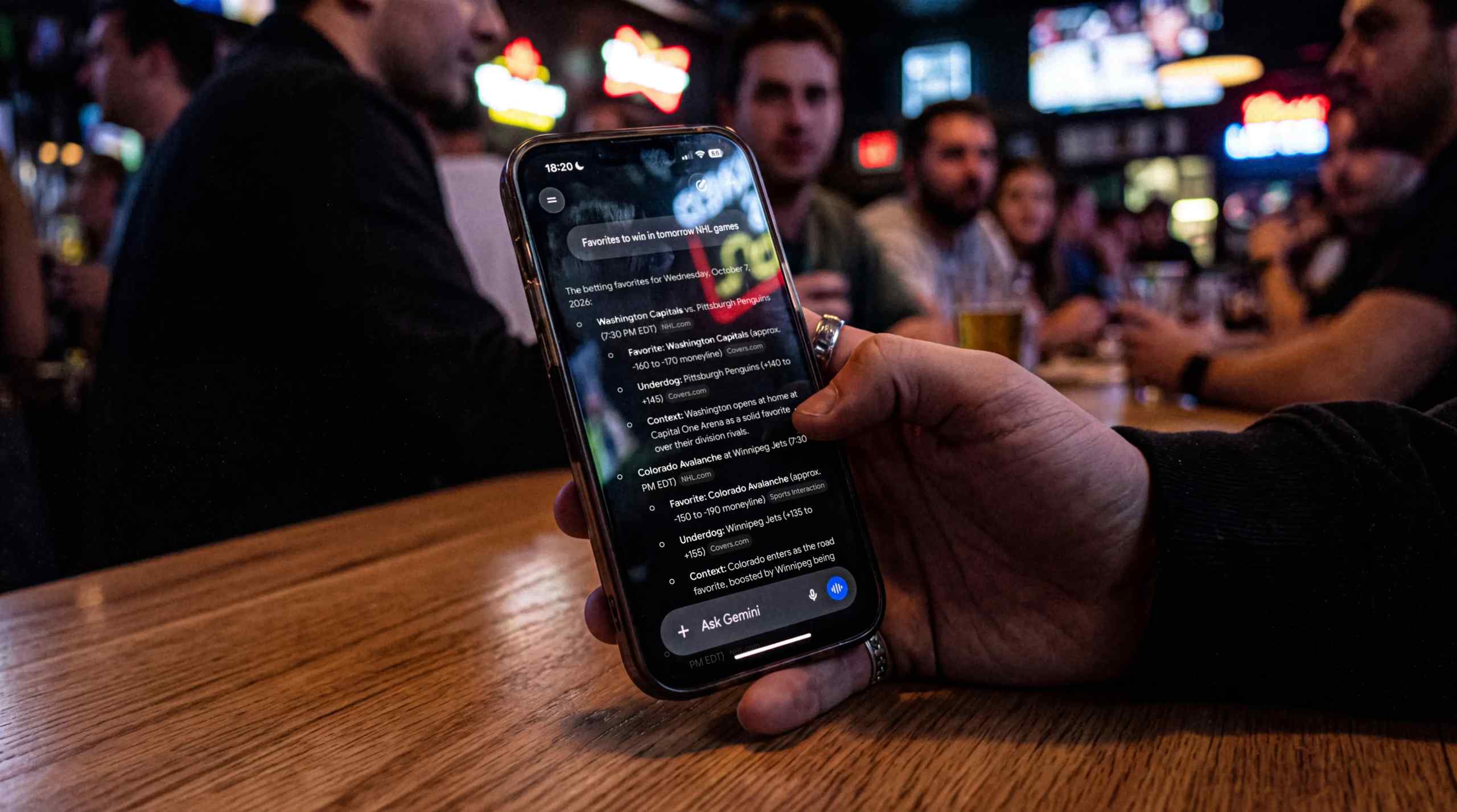 A man checking odds at the bar on his mobile device