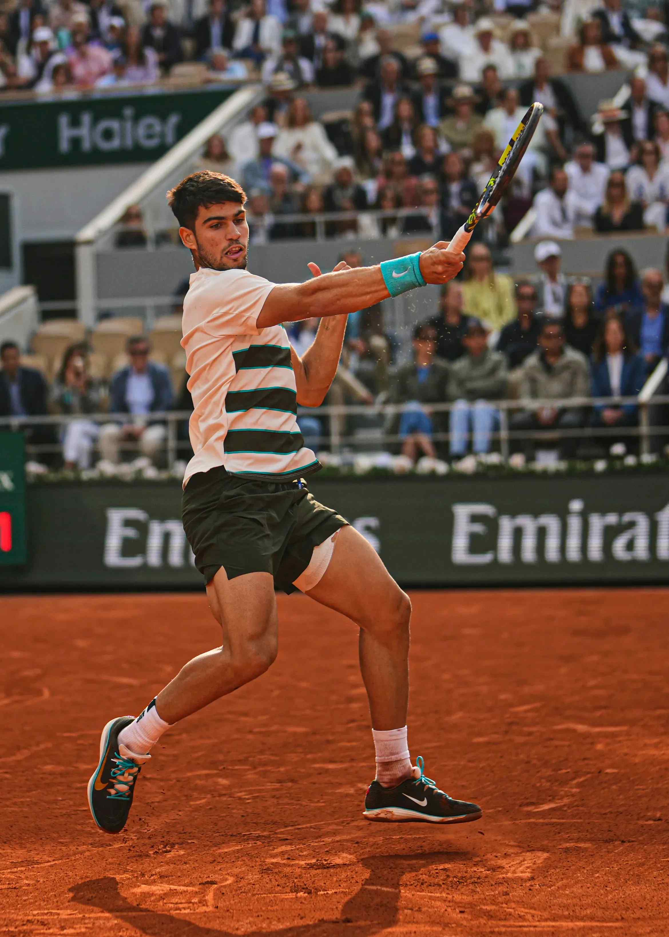 A tennis player mid swing.