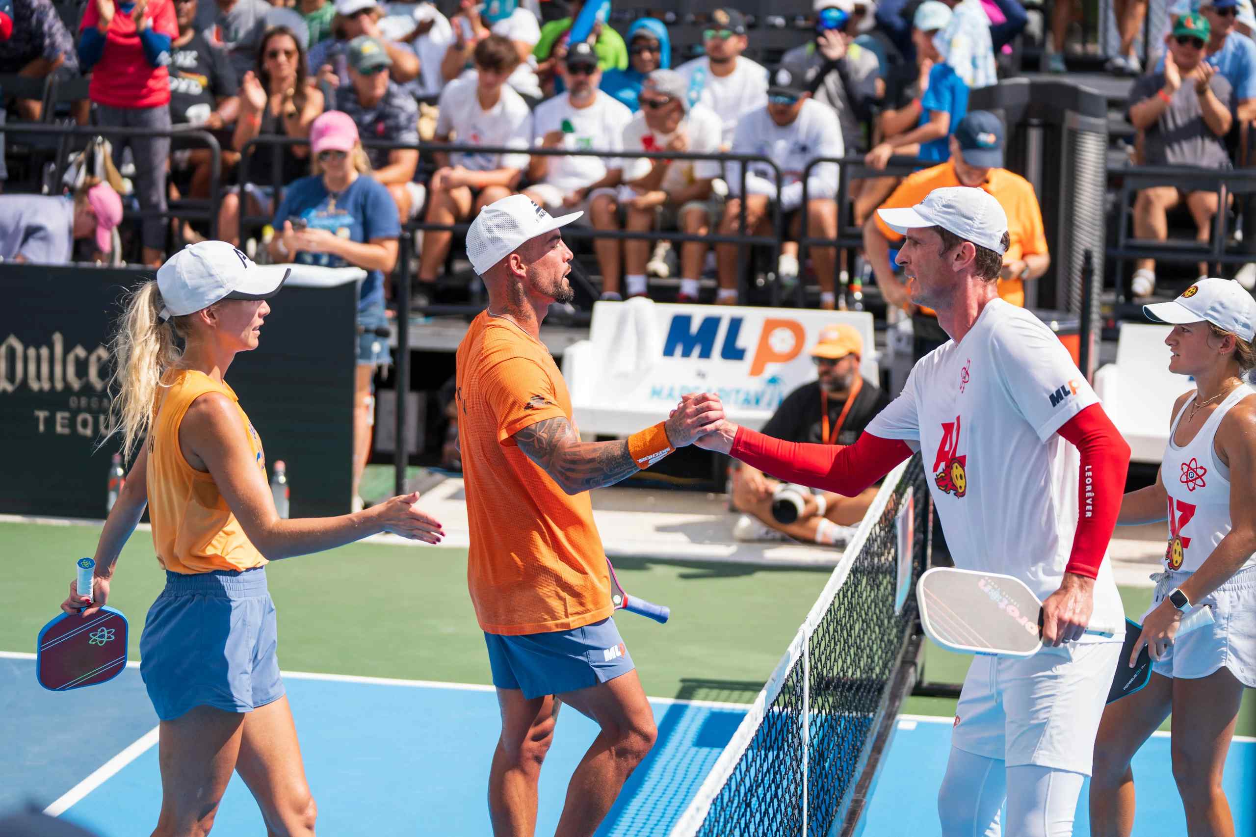 Two teams of pickleball players shake hands after a match.