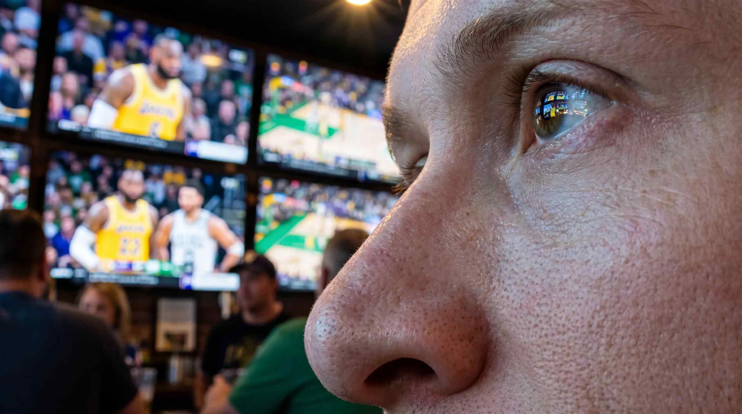 a close up image of a man watching sports in a bar 