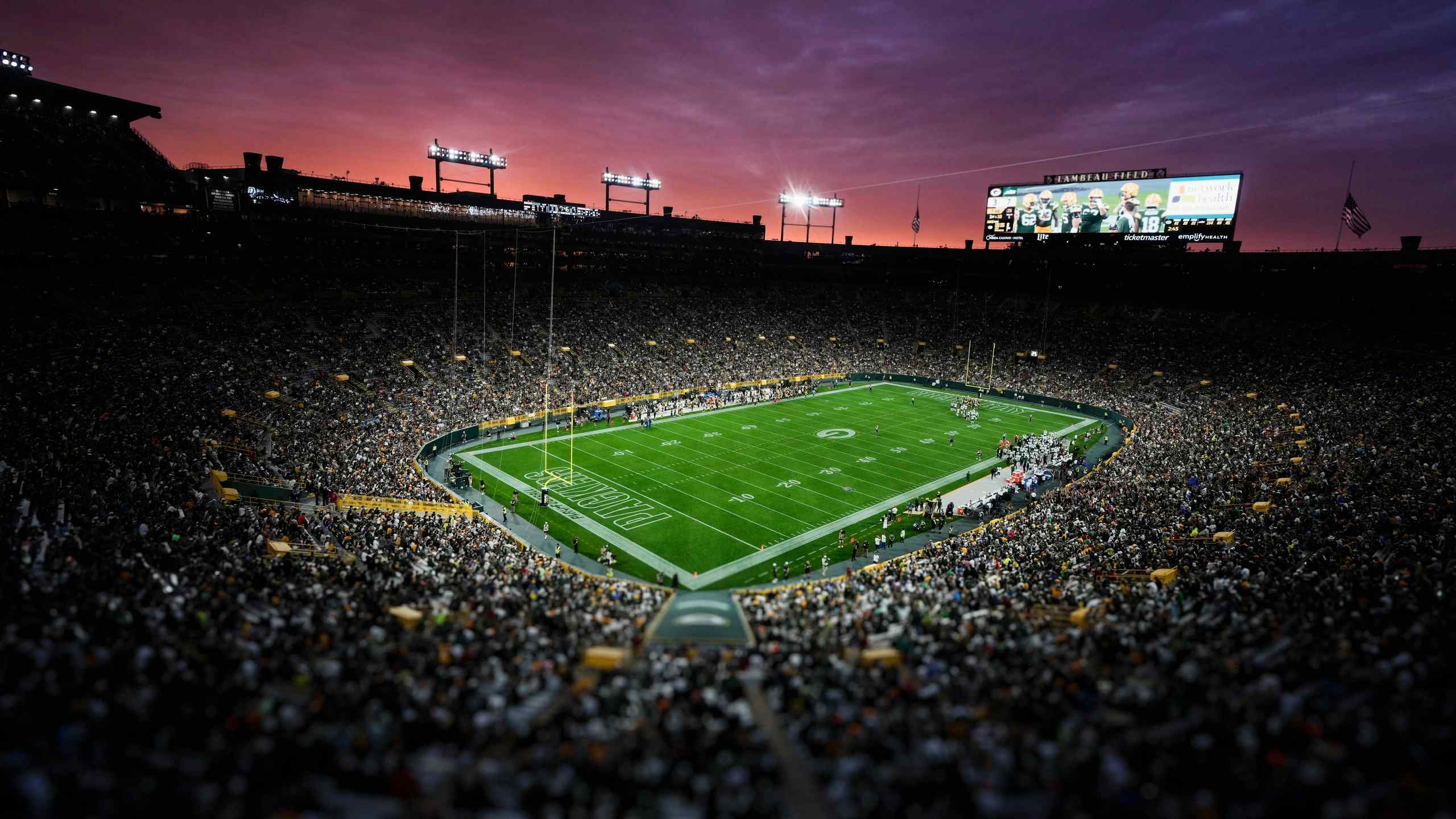 An image of an American football field with a massive crowd.