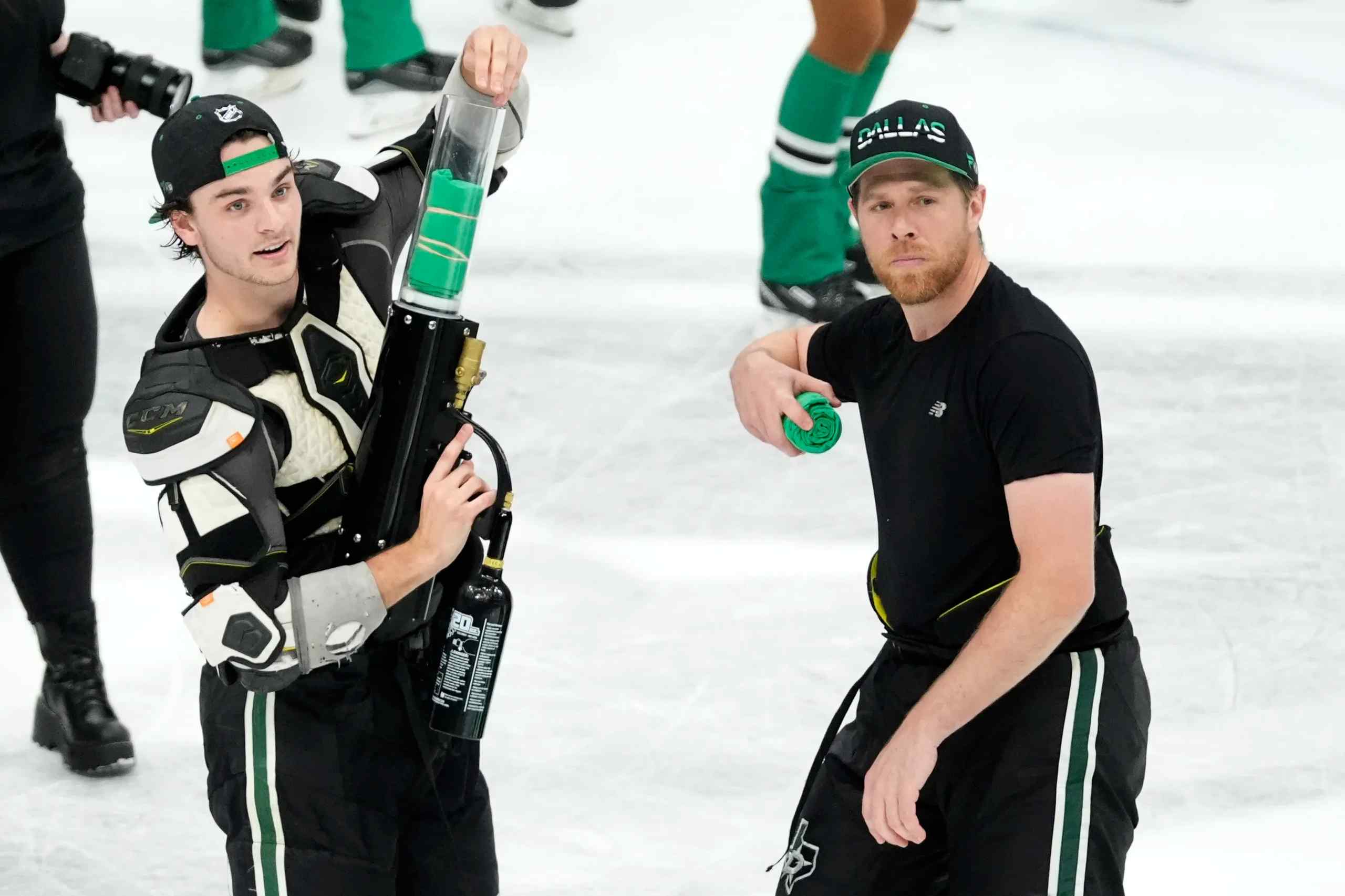 Wyatt Johnson and Joe Pavelski operating the tee-shirt gun on the ice.