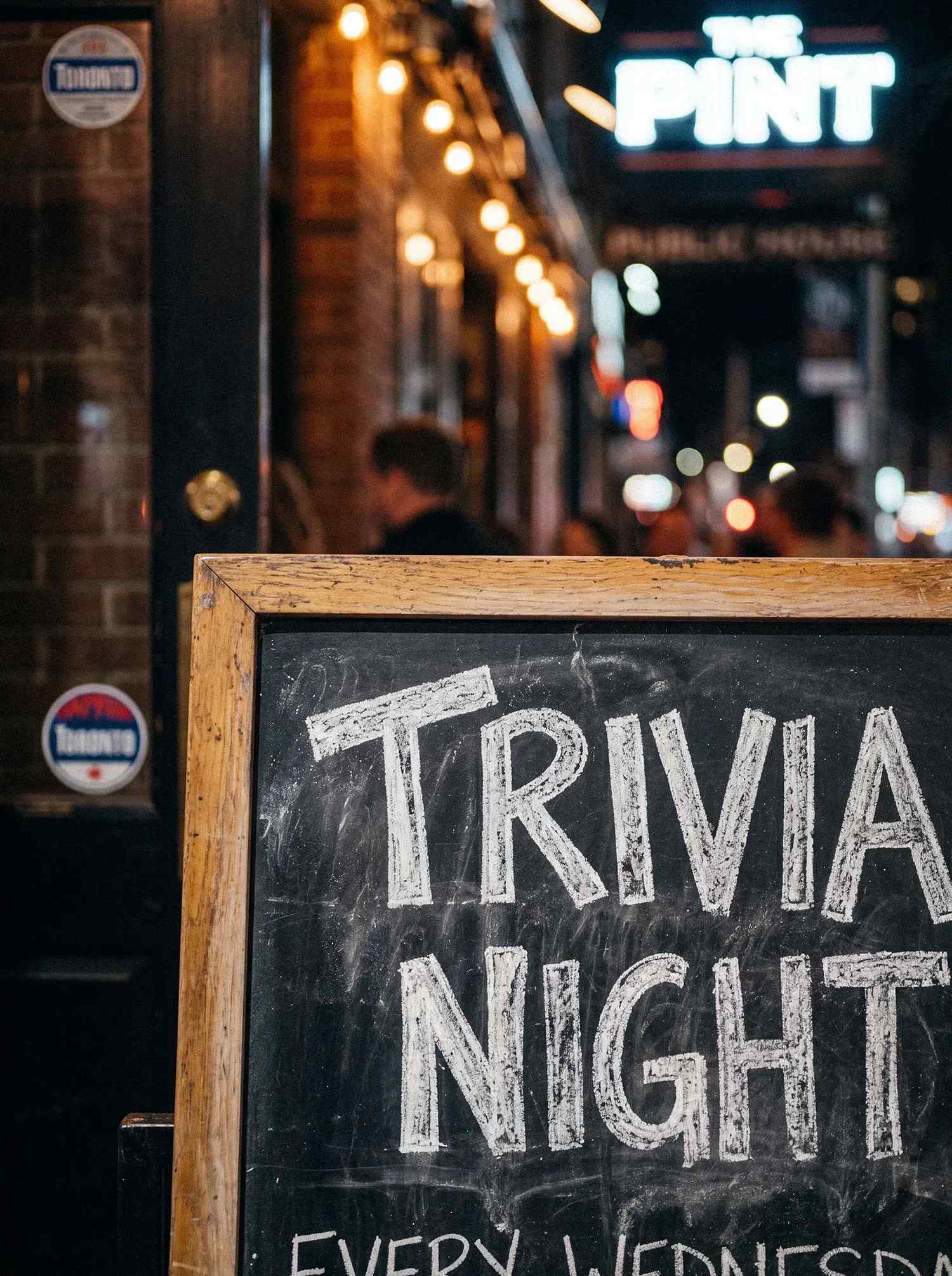 A sign advertising trivia night at a bar.