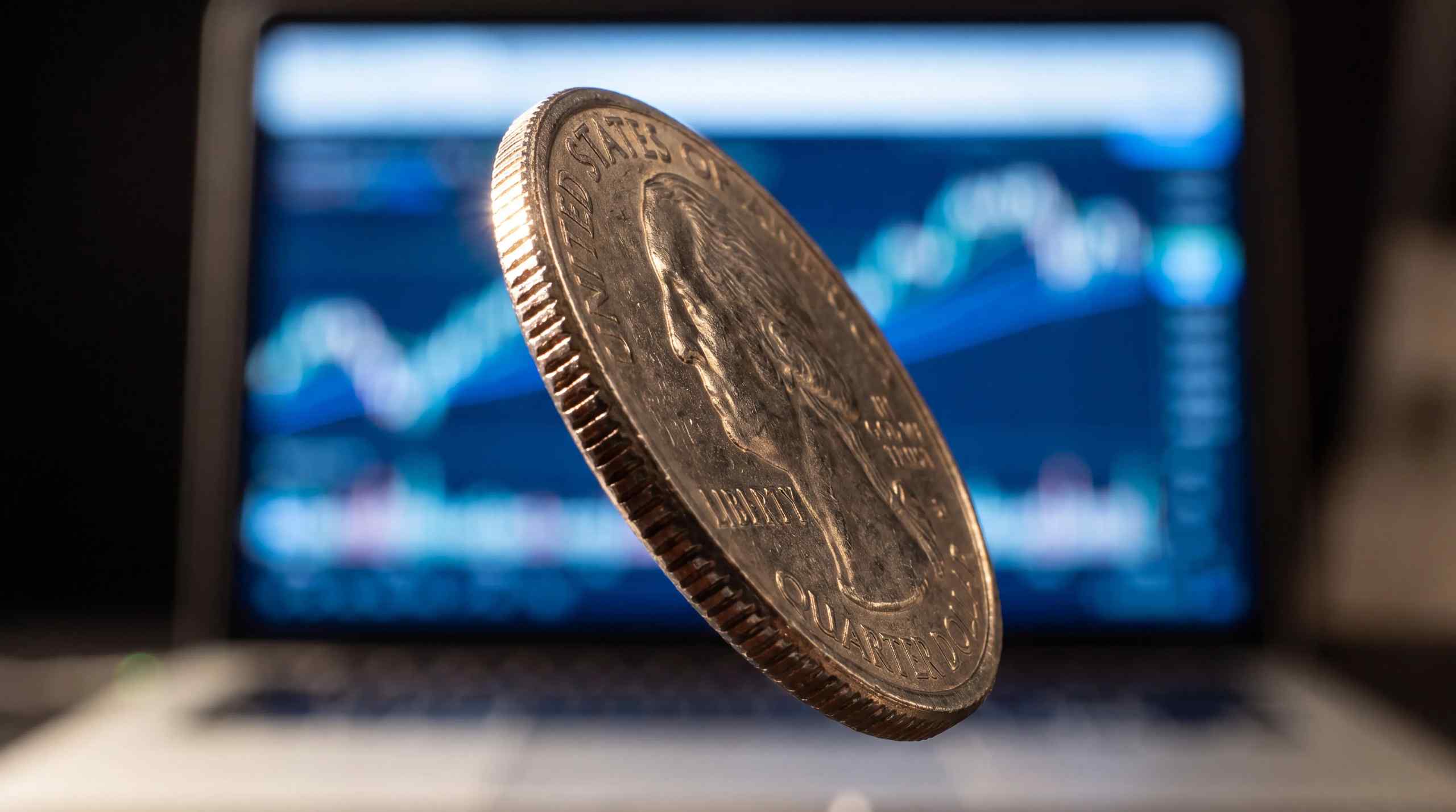 A coin flip in the foreground with a chart in the background.