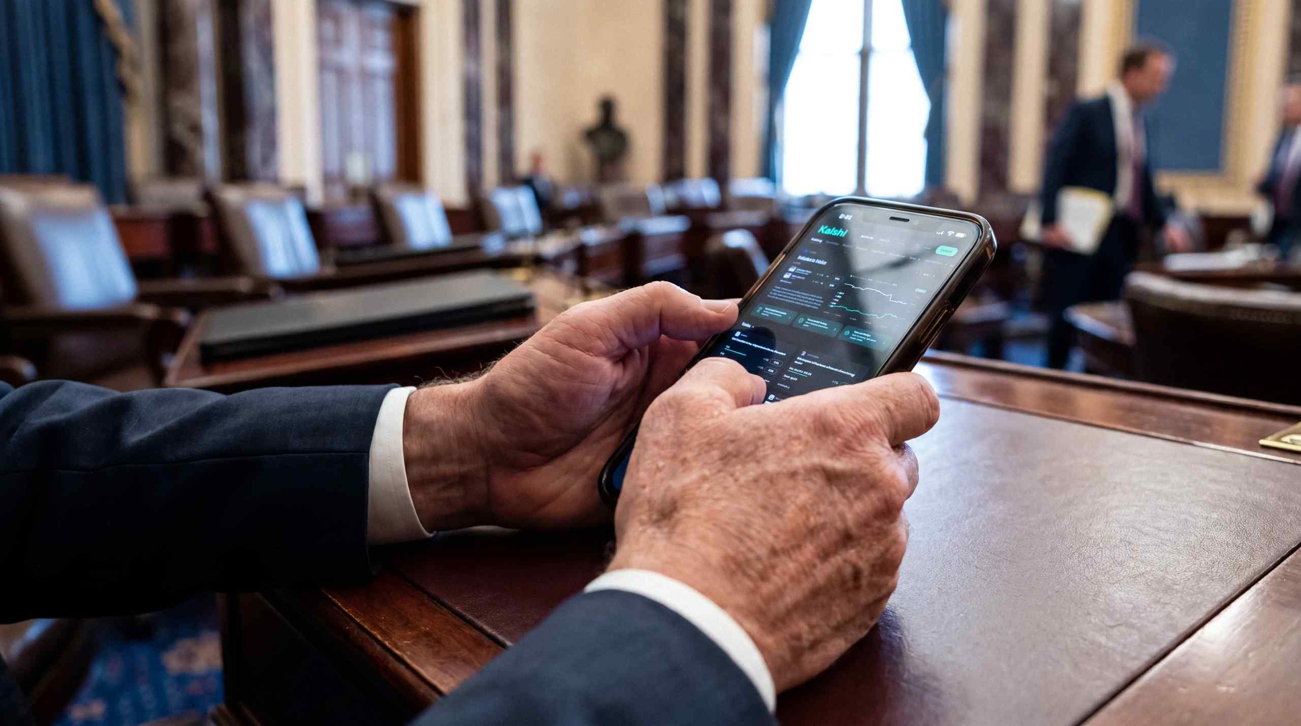 AI image of politician viewing prediction market app on his phone. 