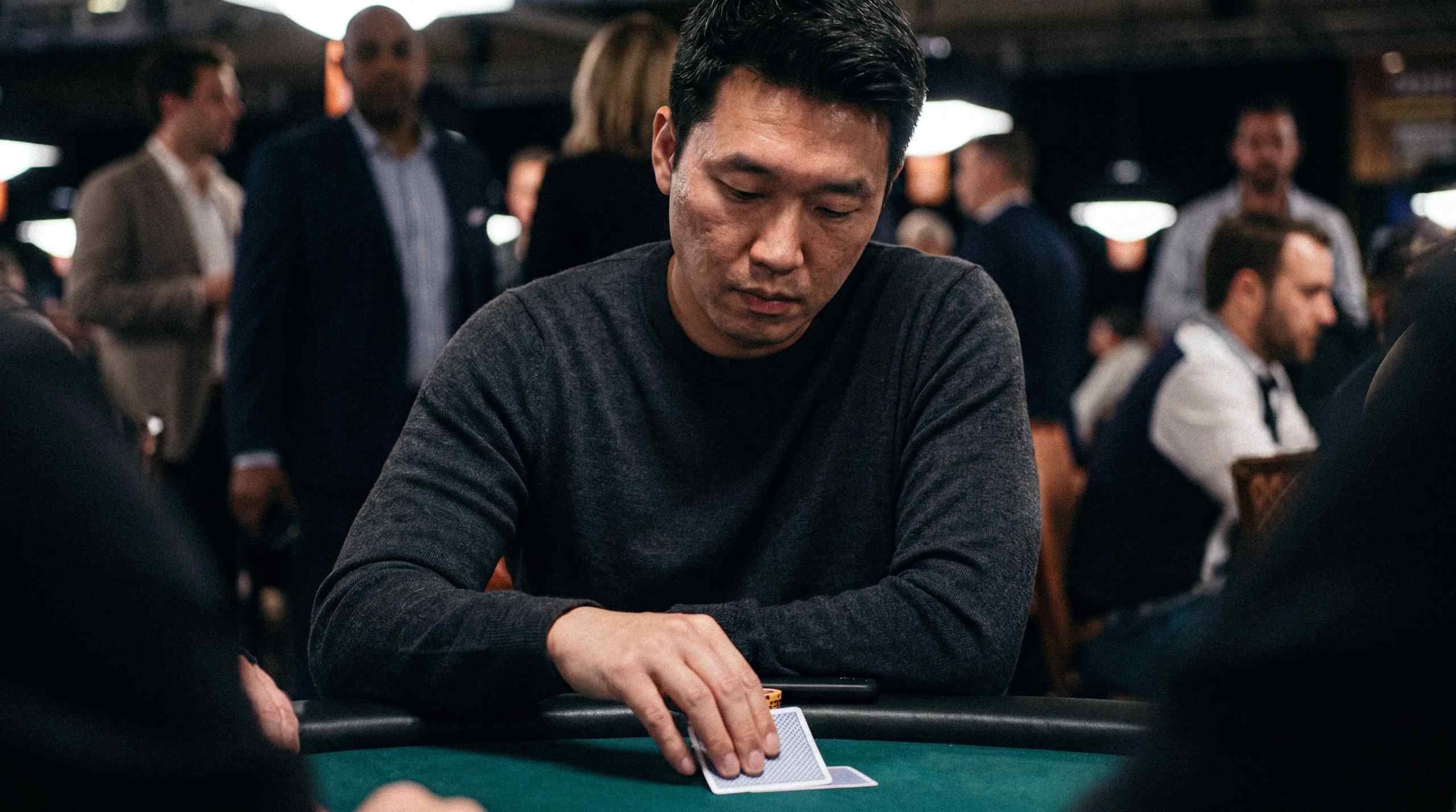 Man looking at his cards at a poker table
