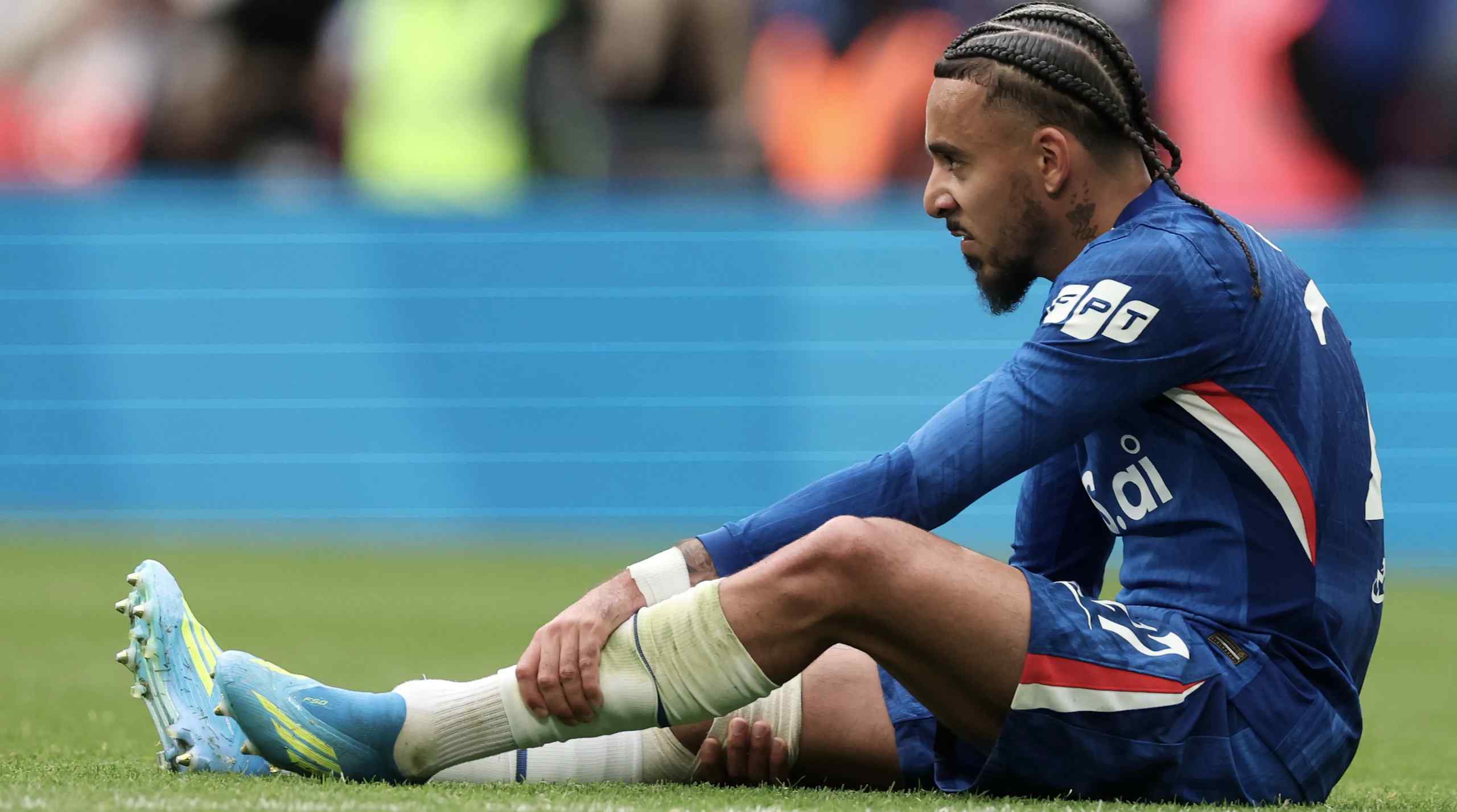 soccer player sitting on the pitch